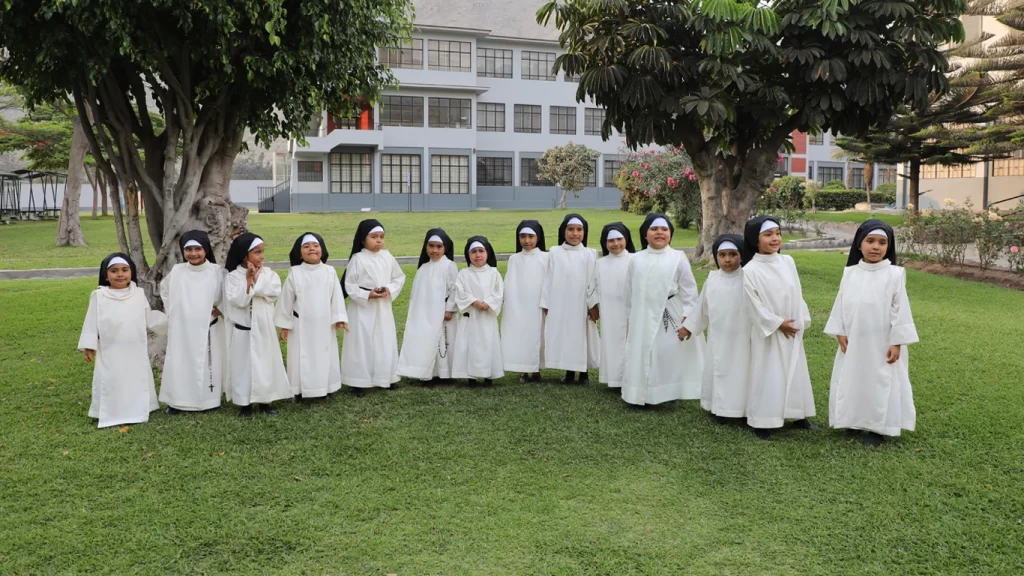 Niñas posan en las áreas verdes del CBI, vestidas de monjas después de finalizado el Kindertag.